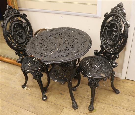 Two cast iron garden chairs and a table W.59cm (table a.f.)